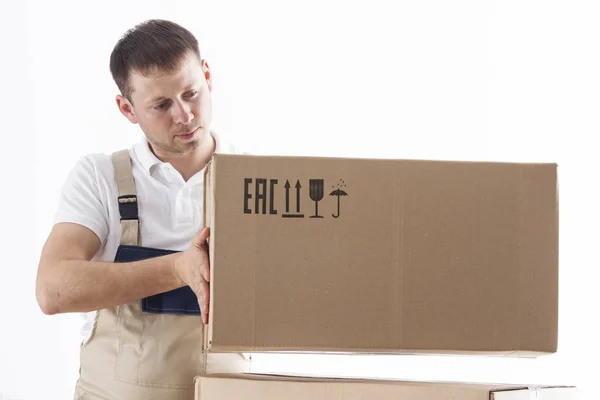 Delivery man puts cardboard box. Relocation service concept. Loader with box. Mover in uniform. — Stock Photo, Image