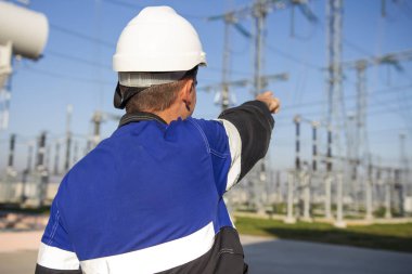 Elektrikçi mühendisi elektrik santrali üzerinde işaret yüksek gerilim donatımı