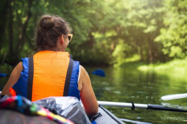 Kayak ve Kano. Ormanda vahşi Nehri üzerinde tekne kürek ile genç kadın yüzüyor. Kano Küreği ile turist kız. Boş zaman etkinliği. Kayık içinde yüzme.