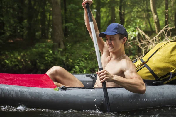 Kajakfahren und Kanufahren. Junger Mann mit Ruder schwimmt im Kajak. Sportler im Boot mit Rudern schwimmen auf dem Fluss. Tourist im Kanu. Freizeitaktivität im Freien. Sporttourismus — Stockfoto