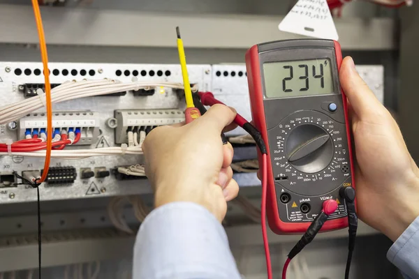 Electrician measurements with multimeter tester. Male Technician Examining Fusebox With Multimeter Probe. Closeup of multimeter in hands of engineer. — Stock Photo, Image