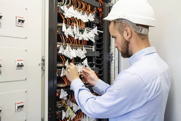 Tekniker ansluter optiska fibrer i kommunikation switch i datacenter. Service mannen i datacenter. Underhåll fungerar kommunikation industriell utrustning. Tjänster engineering. — Stockfoto