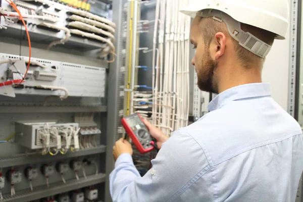 Electrician engineer tests electrical installations and wires