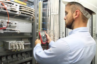 Erkek mühendisi elektrik sistemi ile elektronik araçlar kontrol.