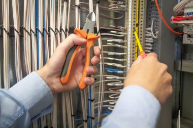 Teller ve kablolar, elektriksel bir kabine elektrikçi bağlanır.