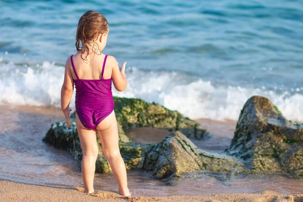 Bayi perempuan kecil di pantai laut dengan pakaian renang — Stok Foto