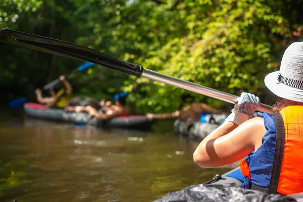 Giovane donna in kayak con remo in fiume selvaggio. Amici di gruppo in canoa — Foto Stock