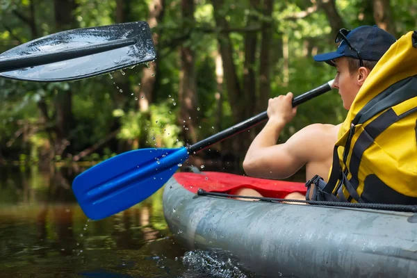 Uomo con pagaie in kayak nuotare lungo il fiume giungla . — Foto Stock