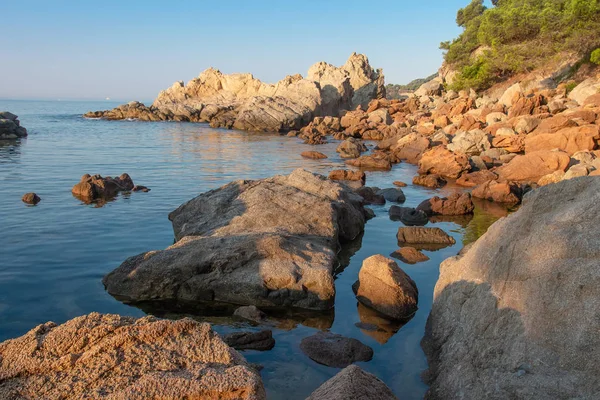 Paisaje marino de playa rocosa con piedras en el agua por la mañana — Foto de Stock