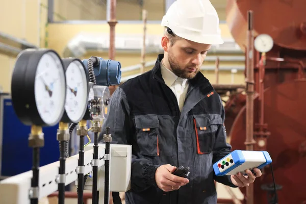 Teknisyen operatör basınç, sıcaklık ve akış gaz ve petrol işleme platformu değerini ölçme işlemi kalitesini izlemek için.