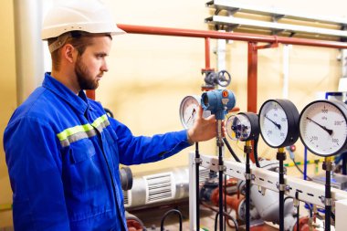 Teknisyen işçi rafineri petrol ve doğal gaz üzerinde basınç manometreler denetler.