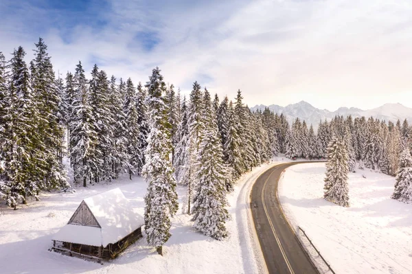 Ahşap ev ve yol karlı dağlarda fantastik kış manzarası — Stok fotoğraf