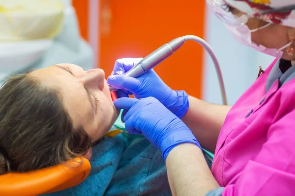 Dentista trata dientes a paciente en clínica dental . —  Fotos de Stock