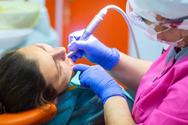 Dentista taladra los dientes del paciente —  Fotos de Stock