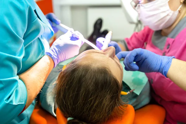 El equipo dental trata los dientes del paciente —  Fotos de Stock