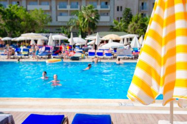 Yüzme havuzu yaz tropikal resort üzerinde arka plan bulanık şemsiyesi.