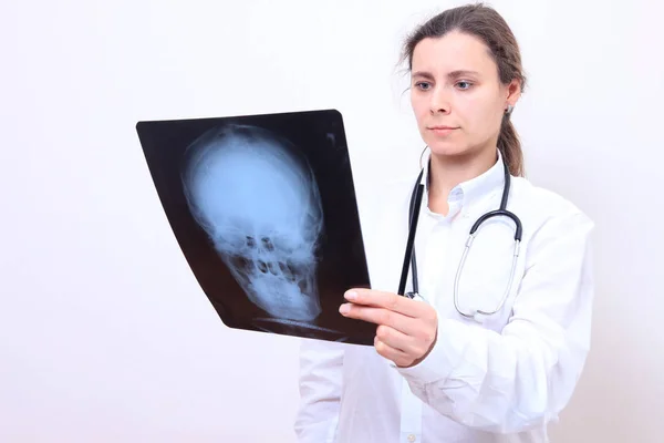 Vrouw arts kijkt x-ray van hoofd — Stockfoto