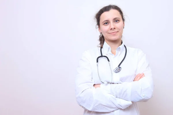 Жінка-лікар зі стетоскопом у білій медичній сукні . — стокове фото