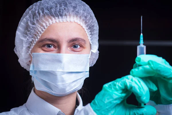 Concepto de salud y medicina - primer plano de la doctora en máscara quirúrgica con jeringa . —  Fotos de Stock