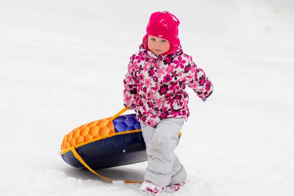 Kind rolt sneeuw bergafwaarts — Stockfoto