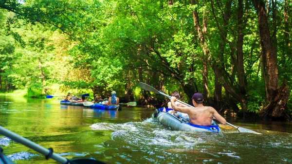 Друзья на каноэ плавают по лесной реке — стоковое фото