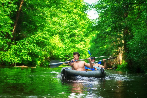 Männer im Boot schwimmen auf dem Fluss. Aktive Freizeit im Freien. Kanu- und Kajakfahren. — Stockfoto