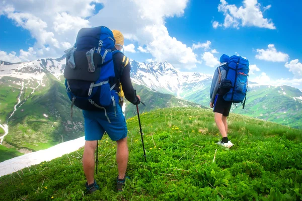 Mochileiros caminham em trilha de montanha. Caminhadas nas montanhas . — Fotografia de Stock