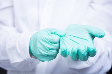 Doktor eller yakından steril eldiven koyar.
