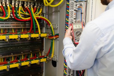 Elektrik kabine testleri için elektrikli cihaz ile çalışan hizmet mühendisi.