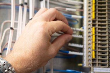 Fusebox yakın çalışma elektrikçi. El bağlamak teller elektrik kabine.