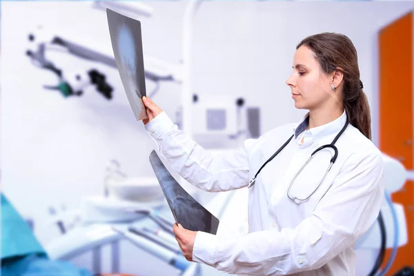 Vrouwelijke arts kijkt naar Xray beelden in de kliniek — Stockfoto