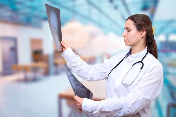 De arts kijkt naar de x-ray beelden op Clinic Hall achtergrond — Stockfoto