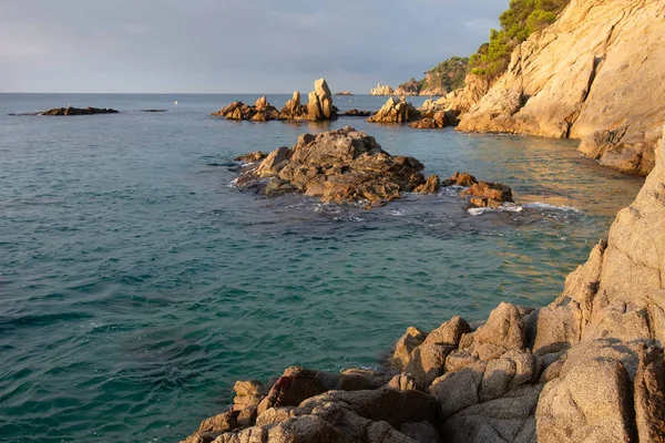 España, Costa Brava paisaje marino. Mar paisaje matutino con acantilados y rocas en el agua cerca de la playa — Foto de Stock