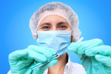 Enjeksiyon için şırınga tutan genç hemşire doktor