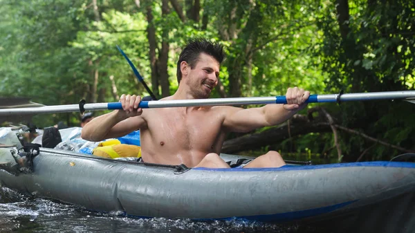 Gutaussehender Kerl in einem Boot paddelt auf Flussrafting. Kajakfahren — Stockfoto