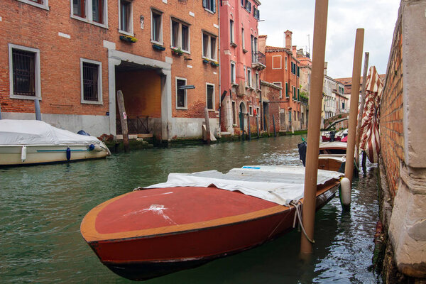 Venice street canal with boat near living buildings, Italy. Veni