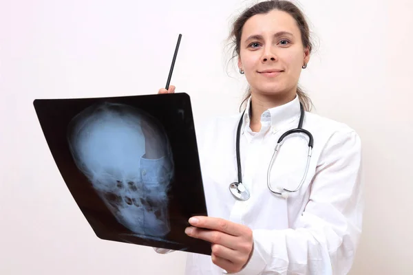 Jonge vrouwelijke dokter met foto 's van het hoofd. X-ray beeld in de hand van fe — Stockfoto