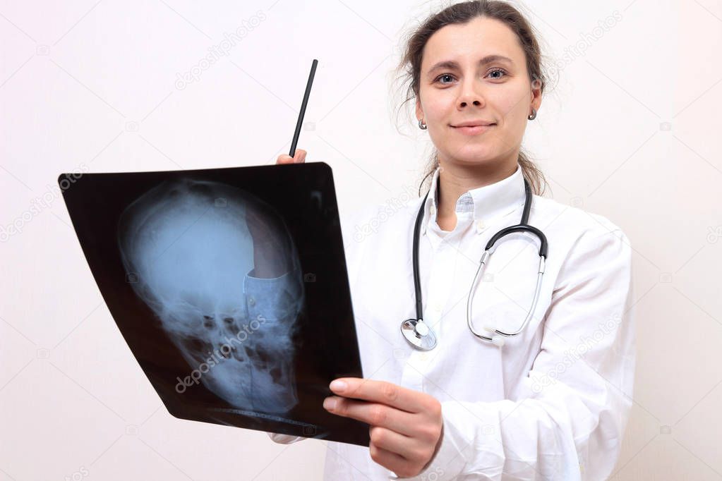 Young woman doctor with xrays of head. X ray image in hand of fe