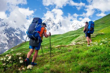 Yürüyüş. Dağlarda trekking. Dağda sırt çantaları olan insanlar