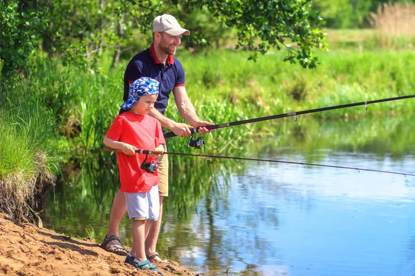 Family on fishing. Father and son with fishing rod catching fish