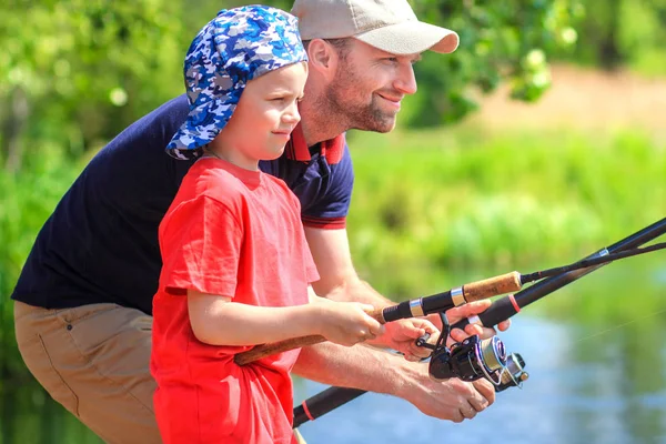 Vater und Sohn beim Angeln. Familie beim Fischfang am Seeufer. h — Stockfoto