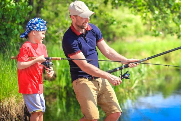 Pescatori lungo il fiume con canne da pesca. Acchiappa padre e figlio — Foto Stock