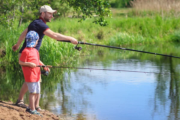 Pesca familiar. Pai e filho com fiação na margem do rio. Activ... — Fotografia de Stock