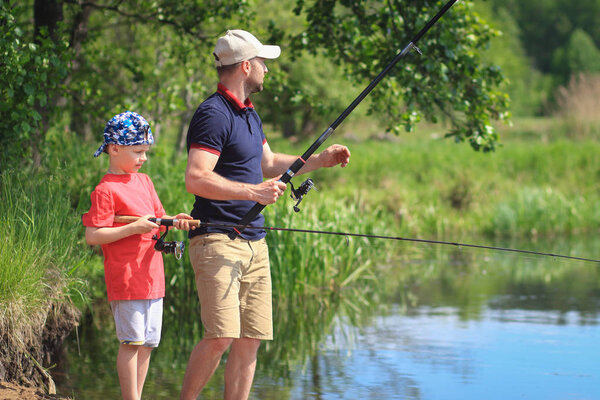 Отец и сын рыбачат. Человек с удочкой ловит рыбу с
 