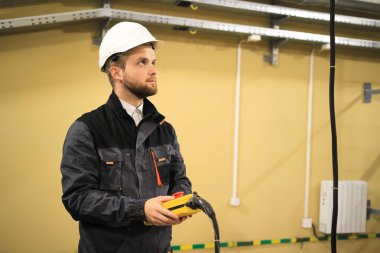 Üniforma giyen teknisyen işçi vinç kiriş için uzaktan kullanır 