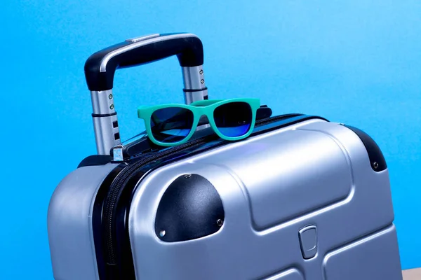 Summer sunglasses and suitcase on blue background. Travel vacati — Stock Photo, Image