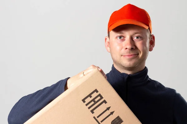 Portrait of man delivery service with cardboard box. Smiling service man. Man holds cardboard box.