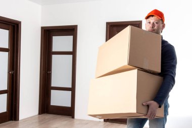 Teslimat işçisi boş evlerde karton kutular taşıyor. Servis nakliyat ve taşıma.