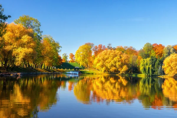 城市公园 秋天的风景公园里美丽的湖景 树上五彩斑斓的叶子 对水的反思 图库照片
