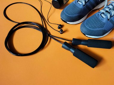 Açık turuncu arka planda spor aksesuarları, fitness ekipmanları